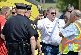 Jeff Lange | The Vindicator  MAY 4, 2015 - Deputy Chief for Mahoning County Hazmat Sil Caggiano (right center) discusses the progress of the leak with police, Monday morning just outside the waste water treatment plant in Youngstown.