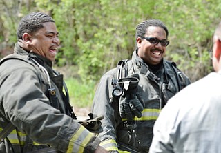Jeff Lange | The Vindicator  MAY 4, 2015 - Firefighters Capt. Perry Harrison (left) and Lt. Christian Brown (center) enjoy a moment of laughter after controlling the leak at the waste water treatment plant in Youngstown, Monday morning.