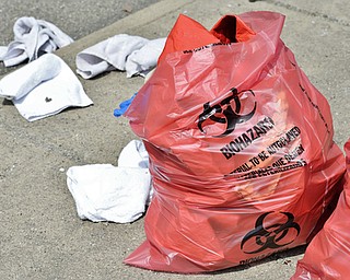 Jeff Lange | The Vindicator  MAY 4, 2015 - Bags of hazardous materials overflowing with rags sit on the sidewalks of Gibson Street just outside of the water treatment plant in Youngstown, Monday morning.