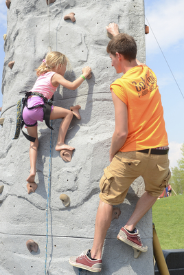 Katie Rickman | The Vindicator.Alli Kanagy 7 of Beloit climbs a rock wall as Tim Loftus of Stow climbs next to her, assisting her in finding her footing at the 5th annual Carnival  at Damascus Elementary School on May 9, 2015.