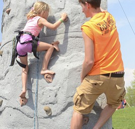 Katie Rickman | The Vindicator.Alli Kanagy 7 of Beloit climbs a rock wall as Tim Loftus of Stow climbs next to her, assisting her in finding her footing at the 5th annual Carnival  at Damascus Elementary School on May 9, 2015.