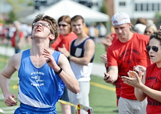 Jeff Lange | The Vindicator  MAY 9, 2015 - Cameron Broom (left) of Stark Public gives it his all as he crosses the finish line in the 1,500 meters run while volunteers applaud during Saturday's Special Olympics at Arrowhead Stadium in Girard.