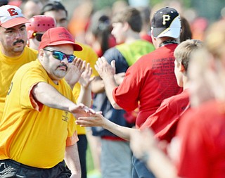 Jeff Lange | The Vindicator  MAY 9, 2015 - Ashtabula County's William Jenner (left) high fives volunteers during the march of athletes prior to the start of Saturday's Special Olympics in Girard.