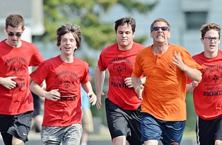 Jeff Lange | The Vindicator  MAY 9, 2015 - Ron Frisbee of Columbiana County Special Olympics (in orange) sprints the final 100 meters of the 1,500 meter run with volunteers of the Girard Special Olympics, Saturday in Girard.