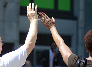 Katie Rickman | The Vindicator.Many attended the National Day of Prayer ceremony downtown Youngstown worshiping and praying on the square on May 7, 2015. A man and woman lift their hands in worship.