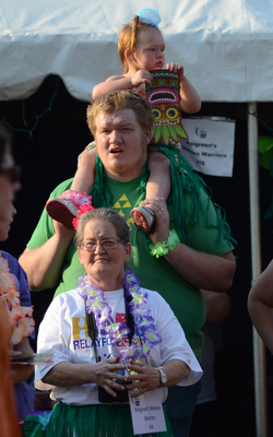 Katie Rickman | The Vindicator.Cody Long of Warren holds his daughter Kira 2 on his shoulders, Angela Long stands in front of them as they wait their turn to walk with other teams at Warren Relay For Life on Friday May 8, 2015.