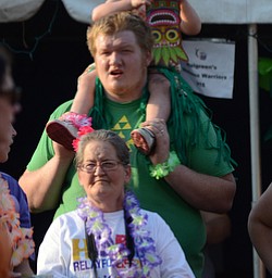 Katie Rickman | The Vindicator.Cody Long of Warren holds his daughter Kira 2 on his shoulders, Angela Long stands in front of them as they wait their turn to walk with other teams at Warren Relay For Life on Friday May 8, 2015.