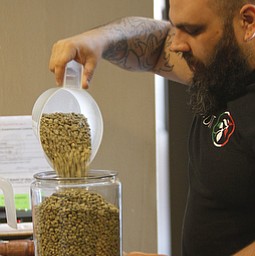        ROBERT K. YOSAY  | THE VINDICATOR..Ben Ilich, 31, of Austintown, carefully measures out the beans as they are mixed together for different flavors ..StoneFruit - Canfield coffee shop t Joshua and Jennifer,(Jennifer Rodway, 25, of Liberty, co-owns the business with her husband, Josh Langenheim, 30, also of Liberty.) married couple, who have imported Roasting machines from heavy coffee countries Morrocco and Turkey. They will also have a coffee shop within the Canfield Public Library once it is open..