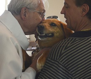 Katie Rickman | The Vindicator. Rev. John Wigle kisses Cinnamon after blessing her as her owner Joe Madbritz of Boardman holds her at the annual Animal Blessing at St. James the Episcopal Church in Boardman on Sunday May 10, 2015.