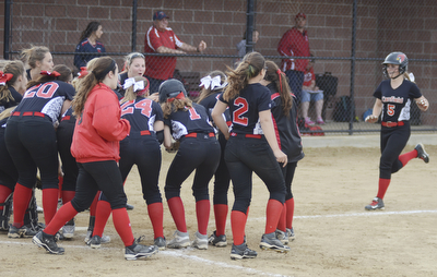 Katie Rickman | The Vindicator.Canfield's Ally Sammarco (5) runs into home base after hitting a home-run, the team waits at the base to celebrate the play during the fifth inning against Girard at Canfield High School on May 12, 2015.