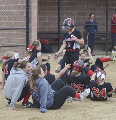 Katie Rickman | The Vindicator.Canfield's Ally Sammarco (5) runs into home base after hitting a home-run as members of the team fall to the ground in celebration during the fifth inning against Girard at Canfield High School on May 12, 2015.