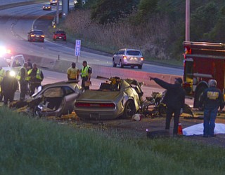 Officials stand near the body of a man who died in a one-car crash on I-680 when his car hit a bridge after rounding a curve.