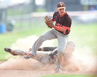 NEW MIDDLETOWN, OHIO - MAY 15, 2015: Second basemen Sam Yarosz #2 of East Palestine plants after hurdling over base runner Hunter Snyder #23 of Springfield after firing him out to end the bottom of the 5th inning during a game Friday afternoon at Springfield High School. (Photo by David Dermer/Youngstown Vindicator)