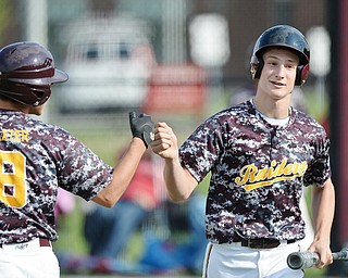 Jeff Lange | The Vindicator  MAY 15, 2015 - South Range's Aniello Buzzacco (right) is congratulated at home by teammate Travis Baxter after being brought home in the bottom of the sixth inning of the Raiders' game against Columbiana, Friday.