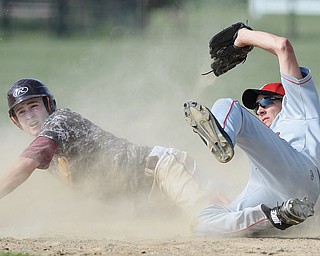 Jeff Lange | The Vindicator  MAY 15, 2015 - South Range's Dylan Keller (left) looks back to the umpire for the call as Columbiana shortstop Devin Rice topples to the ground during fourth inning action of Friday's game at South Range High School. The Raiders edged the Clippers 8-1 and will play East Palestine in a DIII district semifinal at Bob Cene Park on Thursday.