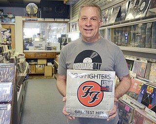 Katie Rickman | The Vindicator.Jeff Burke, owner of The Record Connection in Niles holds a Foo Fighters record as he stands in his record store on May 12, 2015. Burke's store was the location of a performance by Foo Fighters for National Record Store last month, he says his business has picked up since the show.