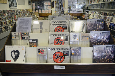 Katie Rickman | The Vindicator.A Foo Fighters display at The Record Connection in Niles holds a Foo Fighters record as he stands in his record store on May 12, 2015. Burke's store was the location of a performance by Foo Fighters for National Record Store last month, he says his business has picked up since the show.