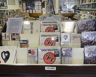Katie Rickman | The Vindicator.A Foo Fighters display at The Record Connection in Niles holds a Foo Fighters record as he stands in his record store on May 12, 2015. Burke's store was the location of a performance by Foo Fighters for National Record Store last month, he says his business has picked up since the show.