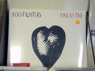 Katie Rickman | The Vindicator.A Foo Fighters album at The Record Connection in Niles holds a Foo Fighters record as he stands in his record store on May 12, 2015. Burke's store was the location of a performance by Foo Fighters for National Record Store last month, he says his business has picked up since the show.