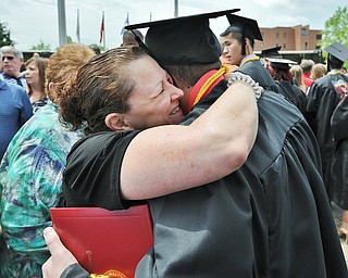 Jeff Lange | The Vindicator  MAY 16, 2015 - Robyn Raymer of Youngstown (left) embraces her son R.J. Raymer after he received his bachelor degree in Information Technology, Saturday afternoon outside the Beeghly Center in Youngstown.