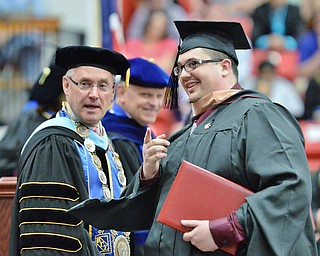 Jeff Lange | The Vindicator  MAY 16, 2015 - Timothy May (right) directs President Jim Tressel to look at a camera for a photo after receiving his masters in Business Administration, Saturday morning during the commencement ceremony at the Beeghly Center.