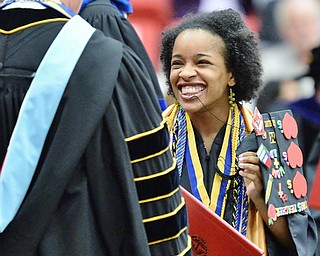 Jeff Lange | The Vindicator  MAY 16, 2015 - Darnella Clark laughs as her cap falls off while walking across the stage after receiving her bachelors degree of Science in Education during YSU's commencement ceremony at the Beeghly Center, Saturday morning.