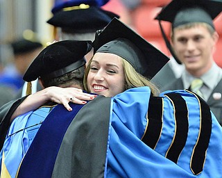 Jeff Lange | The Vindicator  MAY 16, 2015 - Ashley Bowers embraces one of the trustees after accepting her bachelors degree in engineering during Saturday morning's commencement ceremony at YSU.