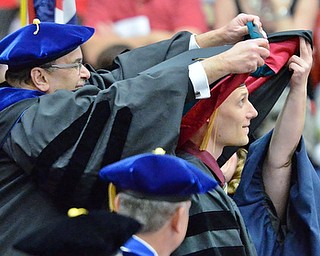 Jeff Lange | The Vindicator  MAY 16, 2015 - Toby Gerez (right) looks up as he receives his physical therapy hood during Saturday afternoon's commencement ceremony at the Beeghly Center. Gerez earned a doctorates degree in physical therapy.
