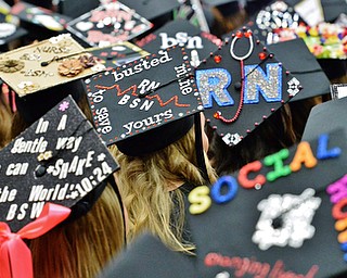 Jeff Lange | The Vindicator  MAY 16, 2015 - Graduates who earned bachelors of science in nursing and students who earned bachelors of social work dawn customized caps during Saturday afternoon's commencement ceremony at YSU.