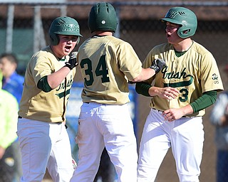 STRUTHERS, OHIO - MAY 22, 2015: Logan Pullin #34 of Ursuline celebrates with teammates Drew Potesta #3 and Brice Bokesch #26 after scoring a run in the bottom of the 1st inning during Friday evenings game at Cene Park. Ursuline won 13-3. (Photo by David Dermer/Youngstown Vindicator)