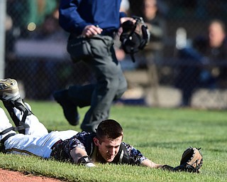 STRUTHERS, OHIO - MAY 22, 2015: Catcher Bryce James #5 of South Range slides on his chest after an unsuccessful attempt to dive and catch a pop up in foul ground in the bottom of the 1st inning during Friday evenings game at Cene Park. Ursuline won 13-3. (Photo by David Dermer/Youngstown Vindicator)