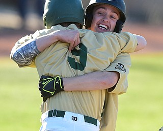 STRUTHERS, OHIO - MAY 22, 2015: Gianni Quattro #12 of Ursuline hugs teammate Joel Hake #9 after crossing home plate to score the game winning run in the bottom of the 6th inning during Friday evenings game at Cene Park. Ursuline won 13-3. (Photo by David Dermer/Youngstown Vindicator)