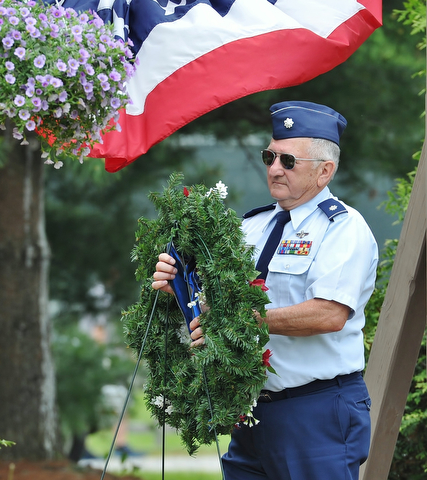 Jeff Lange | The Vindicator  MAY 25, 2015 - Lt. Col. Bill Moss, retired Air Force veteran carries the wreath to honor those who have fallen during Monday's Memorial Day ceremony at Boardman Park.