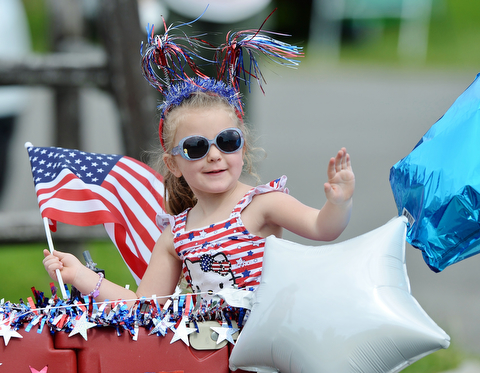 Jeff Lange | The Vindicator  MAY 25, 2015 - Gracie Arquilla of Boardman waves as she rides in a wagon decorated for Memorial Day pulled by Ann Sass of Boardman during Monday morning's Memorial Day Parade at Boardman Park.