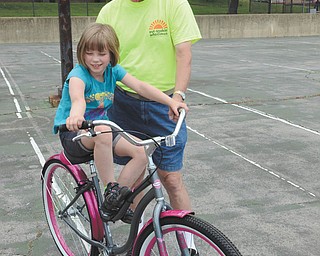 Katie Rickman | The Vindicator
John Nagy, a member of Outspokin’ Wheelmen, holds the bike up for Madison Ray, 8, of Youngstown as she and a few students enjoy the bikes donated to the Rich Center for Autism by the recreational bike club to observe May as National Bicycle Month. 
