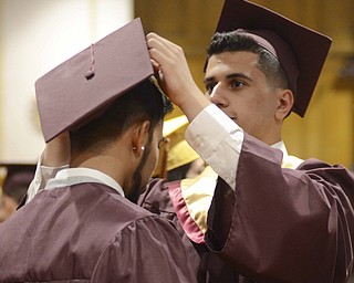 Katie Rickman | The Vindicator.Abdel-Ruhman Yusuf fixes the cap of his friend Virren Vishand Desai prior to the Liberty High School commencement ceremony at Stambaugh Auditorium.