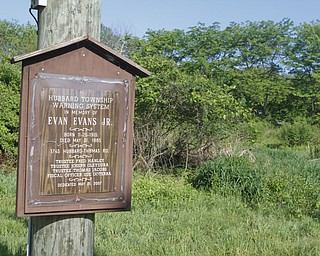        ROBERT K. YOSAY  | THE VINDICATOR..30th of the tornado -..a plaque honors Evan Evans who died in the house behind here that is now a vacant parcel .. atop the post is a tornado siren