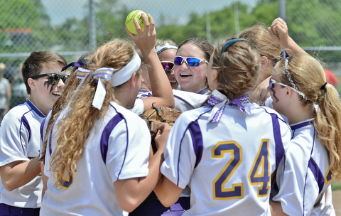 Jeff Lange | The Vindicator  MAY 30, 2015 - Champion catcher Molly Williams (center facing) is surrounded by teammates at home plate after the Flashes' 4-0 victory over the Elyria Catholic Panthers in the regional championship game at Massillon High School, Saturday afternoon.