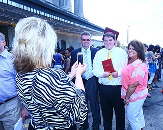 Cindy Delsander takes a picture with her cell phone of friends Ed Horvath Mooney graduate Nicholas Horvath and Sara Horvath today outside the Stambaugh parking lot after commencement.  .