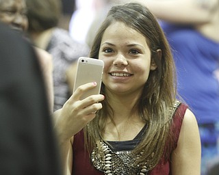        ROBERT K. YOSAY  | THE VINDICATOR.. Jillian Hernandez makes a memory on her cell phone as the graduates file past..Mahoning County High School graduation.the former  P.S. Berry School,