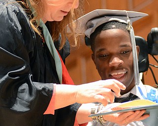Katie Rickman | The Vindicator.Terrence Rankin smiles as he looks at his diploma while his  teacher Carolyn Daugherty (Intervention Specialist) shows it to him after the East High School commencement ceremony at Stambaugh Auditorium on June 5, 2015.