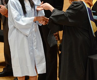 Katie Rickman | The Vindicator.Brandi Alexander shakes hands with Jennifer Damico, principal Choffin Career and Technical Center, as she receives her diploma during the East High School commencement ceremony at Stambaugh Auditorium on June 5, 2015..