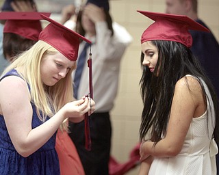       .         ROBERT  K. YOSAY | THE VINDICATOR...Kristina Clemons helps Jacquelyn Cicozi with her tassel -- Over 300 Austintown Fitch graduates received their diplomas at Saturday Morning commencement in the High School Gym..-30-