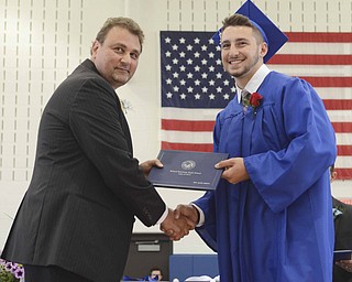 Katie Rickman | The Vindicator.Tate Duarte, on right, shakes hands with Dr. Larry Dinopoulas, a Poland Board Member, after receiving his diploma at Poland High School commencement on Sunday June 7, 2015.