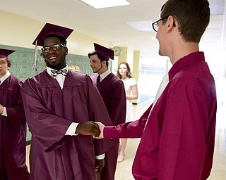 BOARDMAN, OHIO - JUNE 7, 2015: Jaysen Young gets a congratulatory hand shake from teacher Mike Basista, a math teacher at Boardman while walking to the gym for the commencement ceremony Sunday afternoon at Boardman High School. (Photo by David Dermer/Youngstown Vindicator)