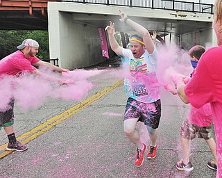 Jeff Lange | The Vindicator  JUNE 13, 2015 - A 2015 Youngstown Color Runner is coated with pink powder as he runs the final kilometer of the Color Run, downtown, Saturday morning.