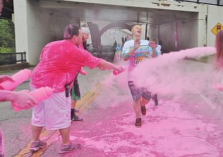 Jeff Lange | The Vindicator  JUNE 13, 2015 - A 2015 Youngstown Color Runner is coated with pink powder as he runs the final kilometer of the Color Run, downtown, Saturday morning.