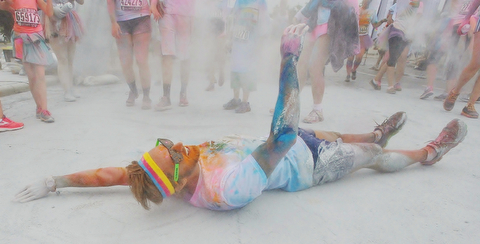 Jeff Lange | The Vindicator  JUNE 13, 2015 - An exhausted runner rolls on the ground after finishing the 2015 Youngstown Color Run, Saturday morning.