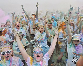 Jeff Lange | The Vindicator  JUNE 13, 2015 - Participants dance and throw colored powder in the air after completing the Color Run 5K race, Saturday morning. Thousands of runners from neighboring areas gathered at the Covelli Centre for the 2015 Color Race in Youngstown.