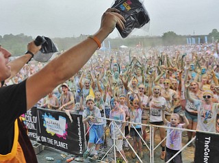 Jeff Lange | The Vindicator  JUNE 13, 2015 - Event MC Conner Tracy (left) gets the crowd fired up after the race by tossing free hats during Saturday's Color Run downtown.